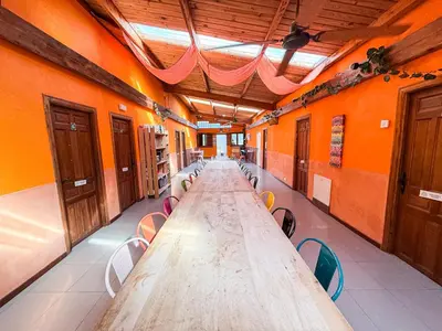 a long long table in an orange room with chairs at Albergue Turístico El Campelín in Ocero