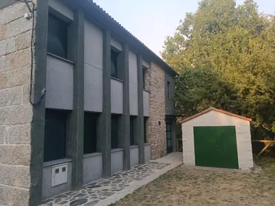 a building with a green door on the side of it at Apartamentos Gabín in Montederramo