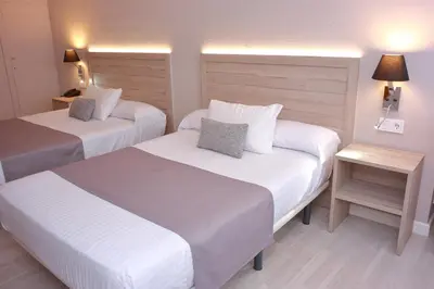 a hotel room with two beds and a table at Hotel Villa de Verín in Verín