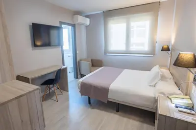 a hotel room with a bed and a desk at Hotel Villa de Verín in Verín