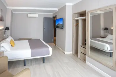 a hotel room with a bed and a mirror at Hotel Villa de Verín in Verín