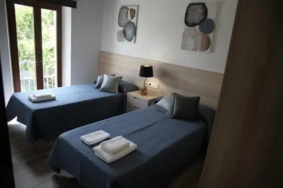 two beds in a room with blue sheets at Casa GHOROS in Boente
