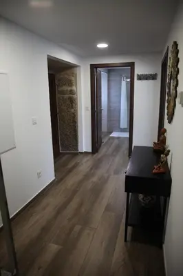 a room with a hallway with wooden floors and a table at Casa GHOROS in Boente