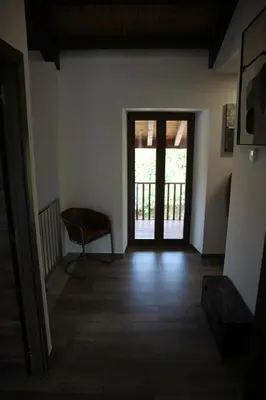 a hallway with a door and a chair in a room at Casa GHOROS in Boente