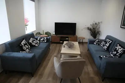 a living room with two blue couches and a coffee table at Casa GHOROS in Boente