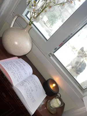 an open book on a desk with a vase and a window at EnGaliciaEs - Casa alquiler turistico en ingles!