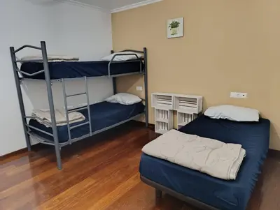 a room with two bunk beds and a bed at Kilómetro99 in Lugo