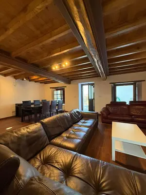 a living room with a leather couch and a table at Casa Chita in Tapia de Casariego