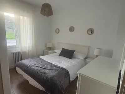 a bedroom with a white bed with a black pillow at El pisito de Cris y Mia in Ponferrada