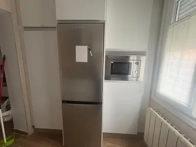 a stainless steel refrigerator with a microwave in a kitchen at El pisito de Cris y Mia in Ponferrada