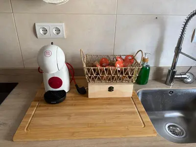 a robot on a cutting board next to a basket of tomatoes at El pisito de la Estrella in Ponferrada