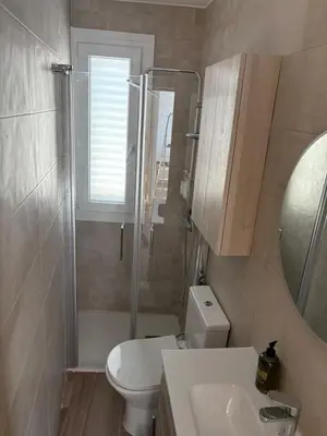 a bathroom with a toilet and a sink and a mirror at El pisito de la Estrella in Ponferrada
