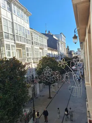 a group of people walking down a street with buildings at Apartamento Centro Calle Reina in Lugo