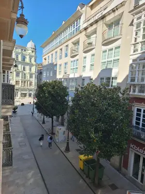 a street in a city with people walking down the street at Apartamento Centro Calle Reina in Lugo