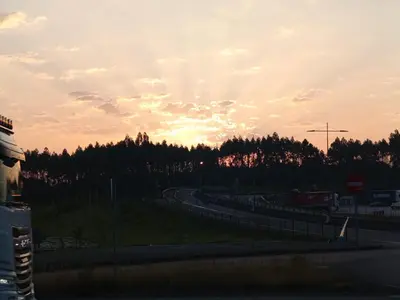 a road with a sunset in the background at habitación mestre 1 in Santiago de Compostela