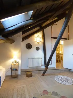 a attic room with wooden beams on the ceilings at Luna Creciente Casa Luna de La Viliella in La Viliella