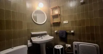 a bathroom with a sink and a toilet and a mirror at Manzaneda Natura T1 in Puebla de Trives