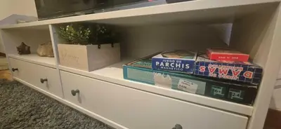 a white dresser with books and boxes on it at Manzaneda Natura T1 in Puebla de Trives