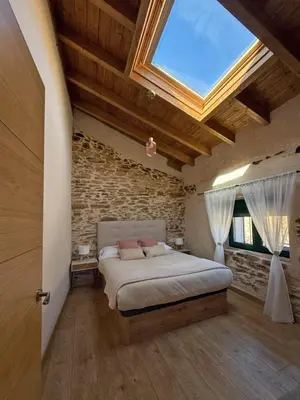 a bedroom with a large bed with a skylight at Casa Veracruz Sanabria in Puebla de Sanabria