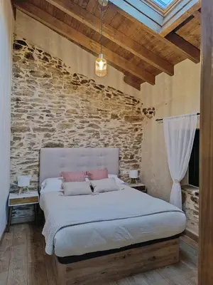 a bedroom with a bed and a brick wall at Casa Veracruz Sanabria in Puebla de Sanabria