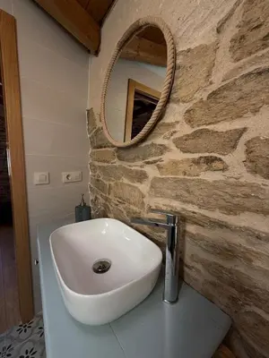 a bathroom with a white sink and a mirror at Casa Veracruz Sanabria in Puebla de Sanabria