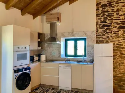 a kitchen with a washing machine and a sink at Casa Veracruz Sanabria in Puebla de Sanabria