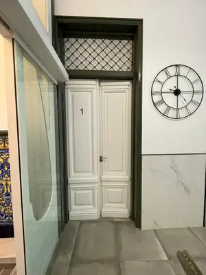 a white door with a clock on a wall at Paseo Malecón Hab in Monforte de Lemos