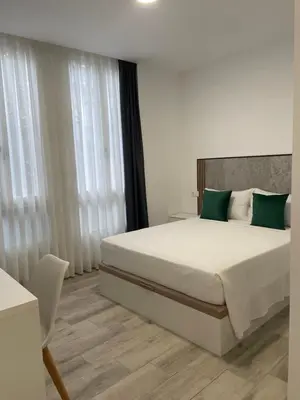 a bedroom with a large bed with green pillows at Paseo Malecón Hab in Monforte de Lemos