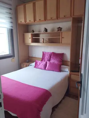 a bedroom with a large bed with pink pillows at Casa Belén in Burela de Cabo