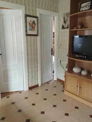a living room with a television and a tiled floor at Casa Belén in Burela de Cabo