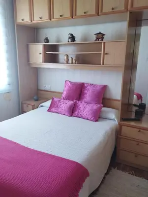 a bedroom with a bed with purple pillows at Casa Belén in Burela de Cabo