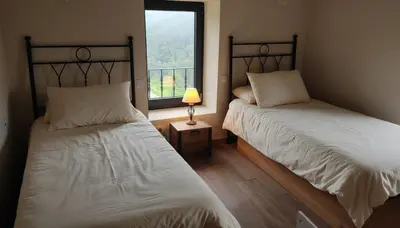two beds in a room with a window at La casa de las ovejas