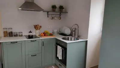 a kitchen with white cabinets and a sink and a stove at La casa de las ovejas