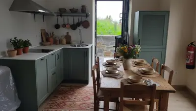 a kitchen with a wooden table with chairs and a tableasteryasteryasteryasteryastery at La casa de las ovejas