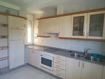 a kitchen with white cabinets and a sink at Casa do Pina in Villarmayor