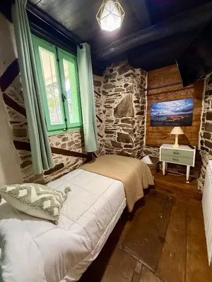 a bedroom with a bed and a stone wall at Meson el Acebo in El Acebo de San Miguel