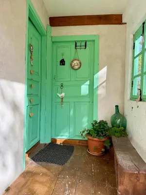 a green door with a bench in front of it at Meson el Acebo in El Acebo de San Miguel