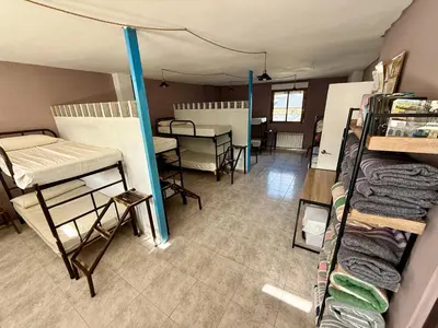 a room with bunk beds and a table in it at Meson el Acebo in El Acebo de San Miguel