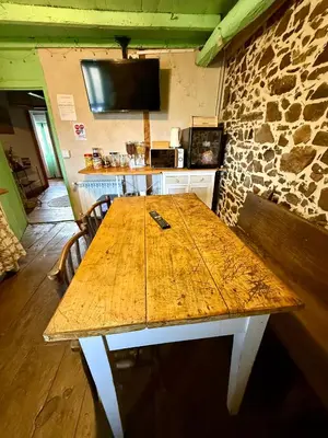 a wooden table in a room with a stone wall at Meson el Acebo in El Acebo de San Miguel