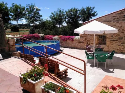 a patio with a table and an umbrella and a swimming pool at REMANSO DE TRASFONTAO 