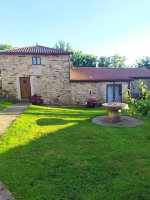 a stone house with a bench in the yard at REMANSO DE TRASFONTAO 