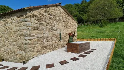 a stone building with a wooden chest in front of it at REMANSO DE TRASFONTAO 