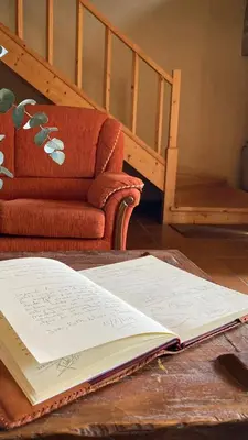 an open book on a table next to a couch at Casa Rural A Avoa María in Campo Lameiro