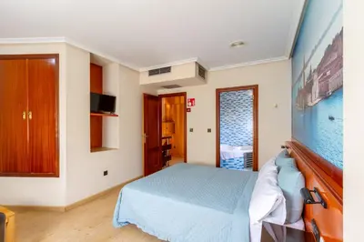 a bedroom with a bed and a tv on the wall at Motel Venecia in Taboadela