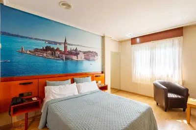 a bedroom with a bed and a large painting on the wall at Motel Venecia in Taboadela