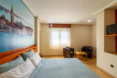 a bedroom with a bed and a large painting on the wall at Motel Venecia in Taboadela