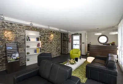 a living room with a couch and a green chair at Apartamentos Viavelez in La Caridad