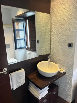 a bathroom with a sink and a large mirror at Apartamentos Viavelez in La Caridad
