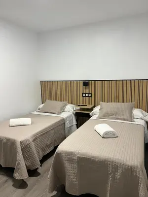 a room with two beds with towels on them at Pensión Ferreiriño in Quiroga