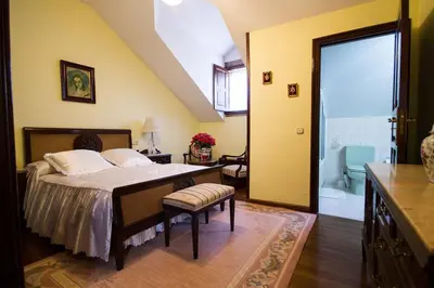 a bedroom with a bed and a bathroom at Pazo do Vilar in Padrón